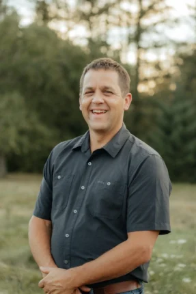 Warren smiling for a professional outdoor portrait in Vancouver, WA, wearing a black button-down shirt.