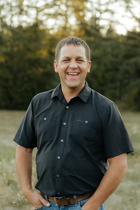 Warren smiling for a professional outdoor portrait in Vancouver, WA, wearing a black button-down shirt.