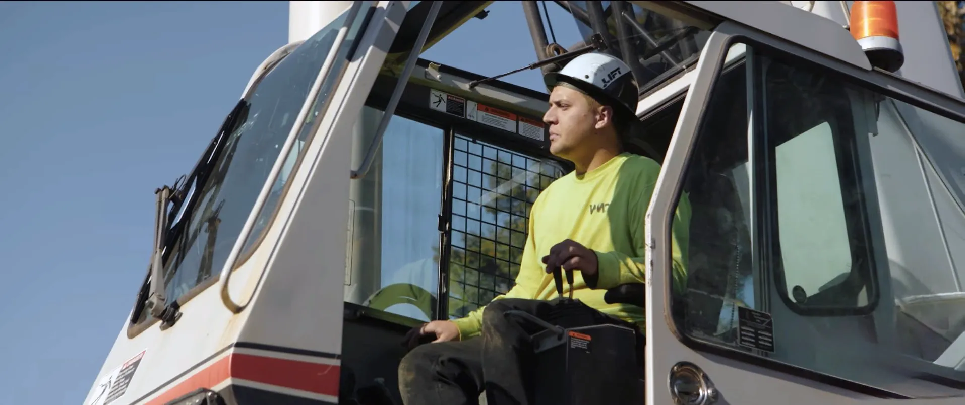 Professional crane operator from Westmore Construction in Vancouver, WA, expertly managing heavy machinery from the cab of a Link-Belt truck crane on a local job site.
