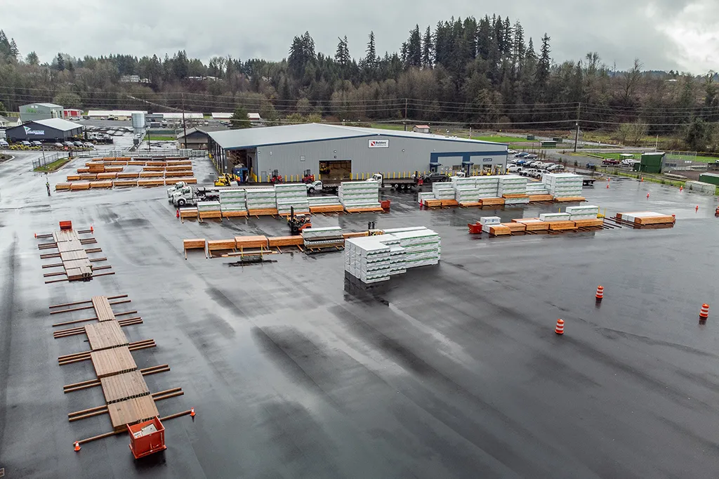 Aerial view of a large Westmore Construction industrial lumber yard and distribution facility in Vancouver, WA, featuring organized building materials.