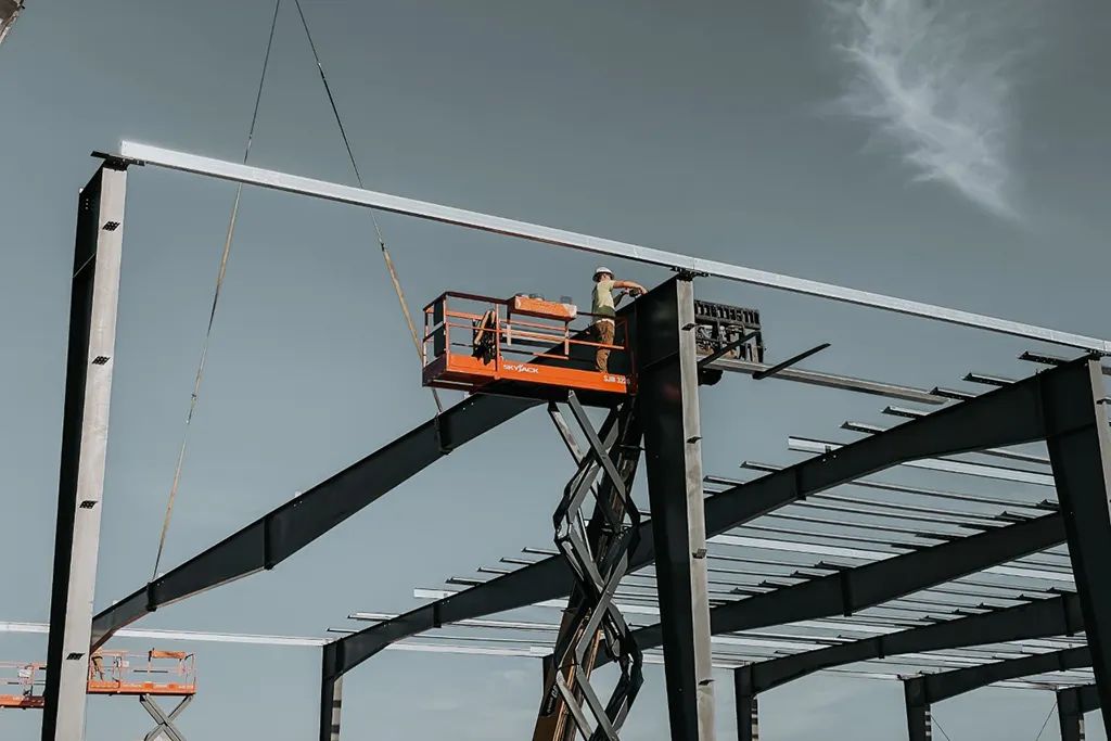 Westmore Construction worker on a scissor lift installing heavy-duty steel beams for a commercial building project in Vancouver, WA.