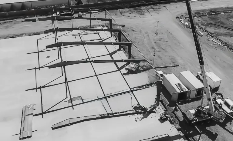 Black and white aerial view of a 55-ton crane and construction crew working on a large metal building project in Vancouver, Washington.
