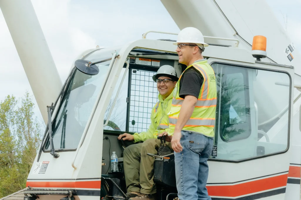 Professional Westmore Construction crane operators in safety gear coordinating a heavy lift for a commercial project in Portland.