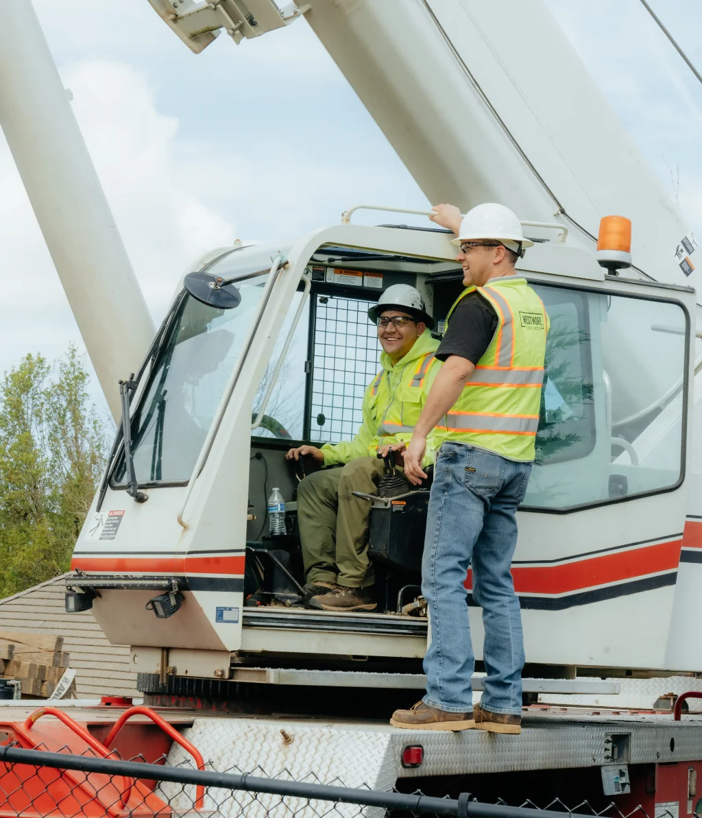 Professional Westmore Construction crane operators in safety gear coordinating a heavy lift for a commercial project in Portland.