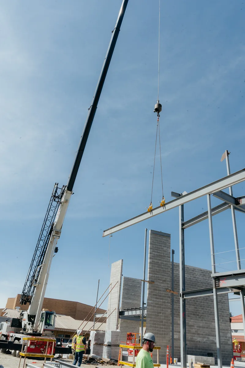 Westmore crane lifting a steel beam onto a frame at a commercial jobsite