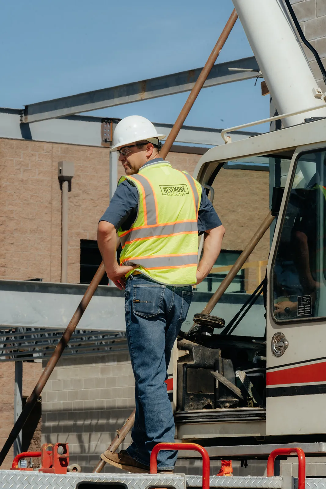 Westmore crew member standing on the crane deck beside a CMU wall