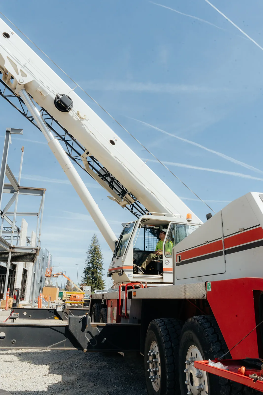 Westmore crane outriggers and counterweight set beside tilt-up panels, operator in the cab