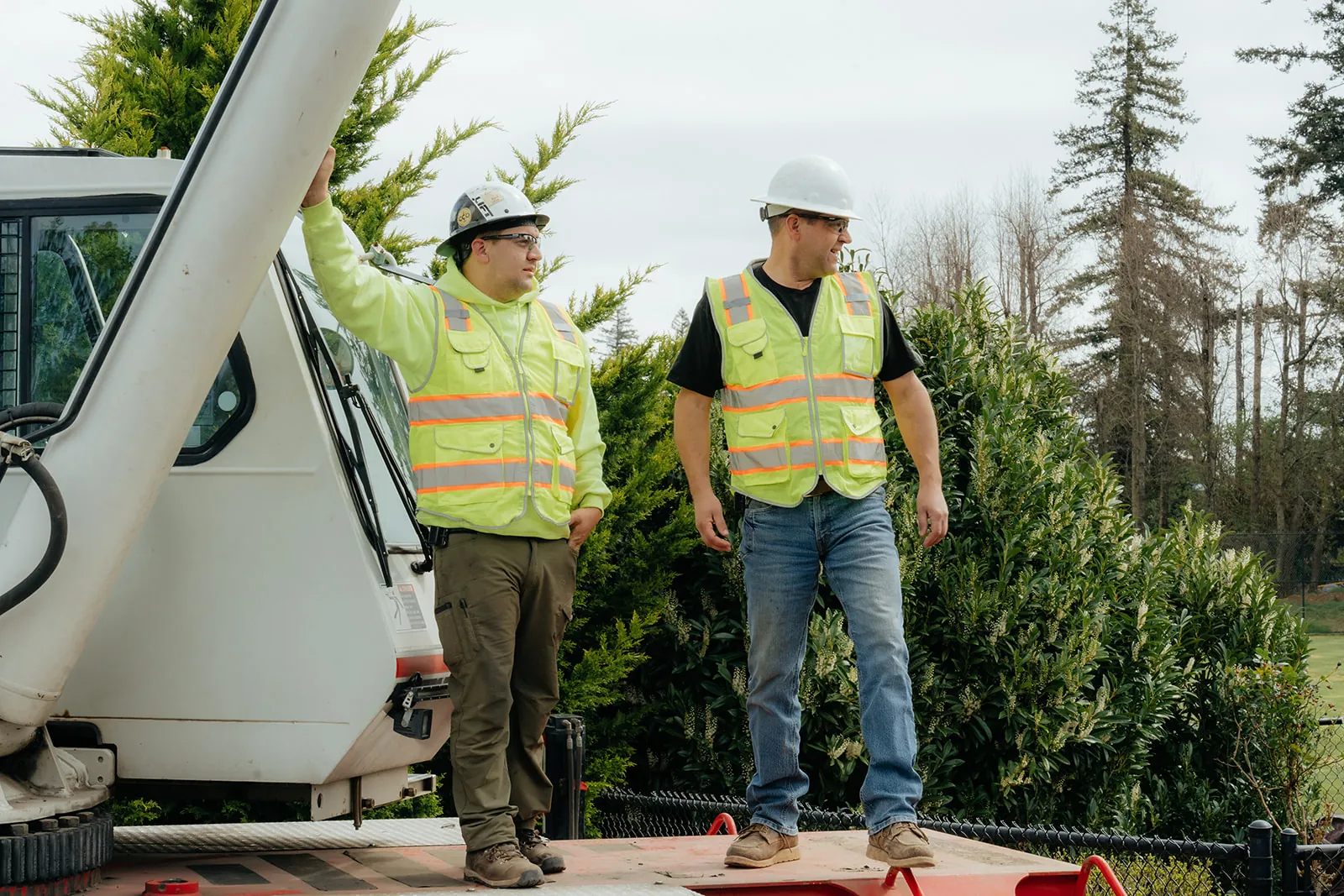 Two Westmore crew members standing on the crane deck with evergreen trees behind