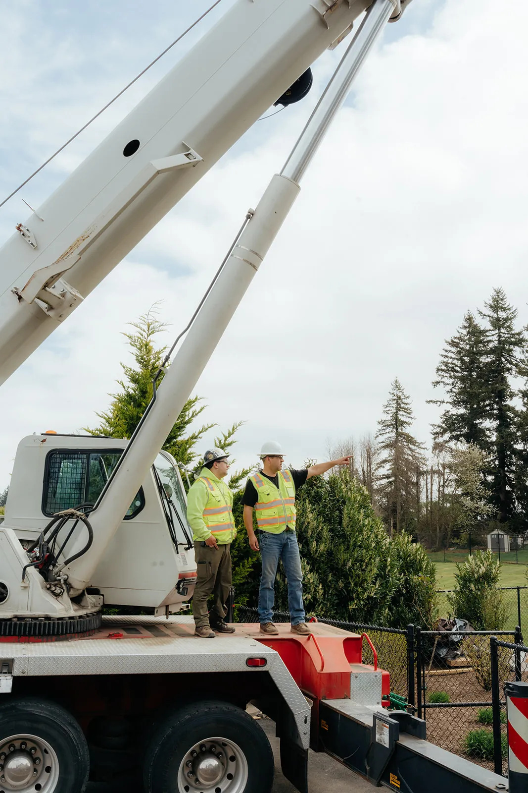 Westmore crew member pointing up toward a crane boom during lift setup