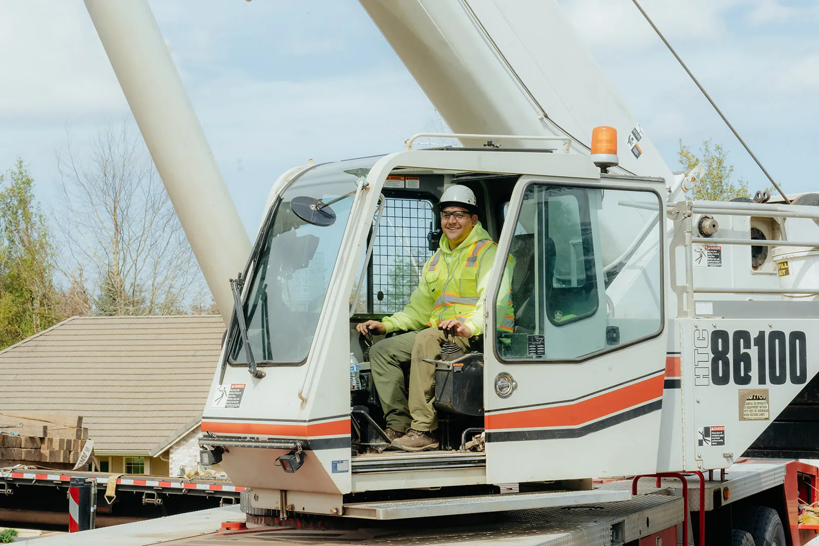 Westmore operator seated in the Link-Belt crane cab with crew at the door