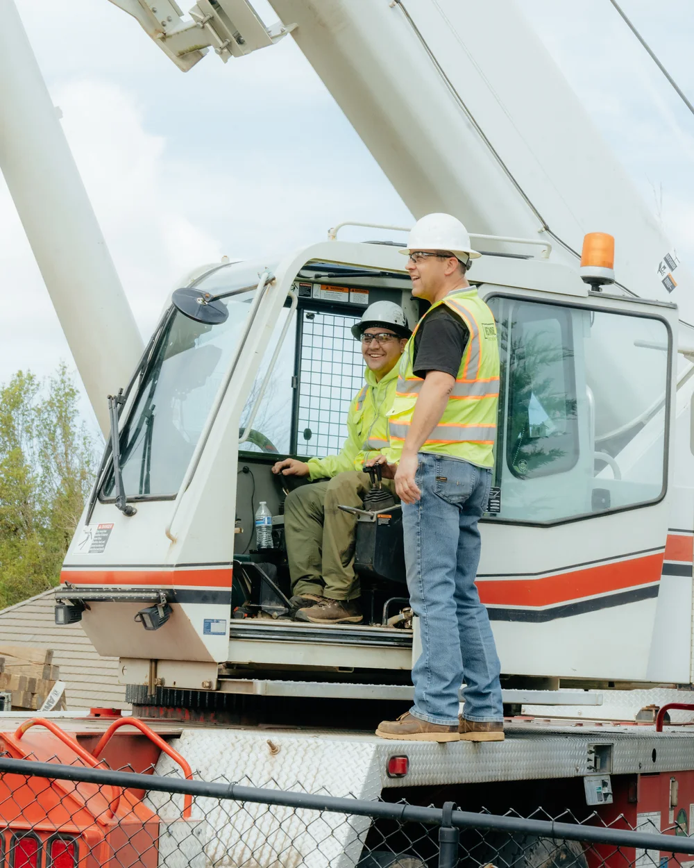 Westmore crew smiling at the crane cab with booms overhead