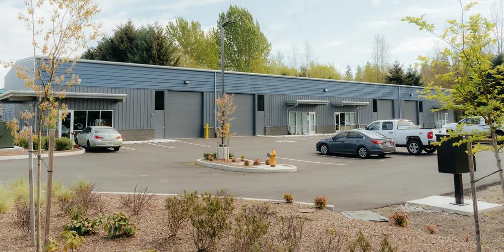 A completed commercial office and warehouse building with parking